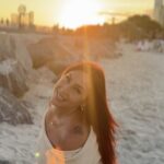 Icielani looking toward the camera on a beach at sunset. Artist-supplied campaign photograph.