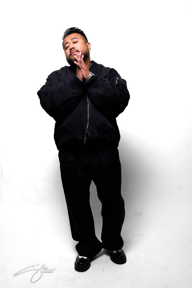 Rocky Sandoval in a black outfit against a white studio background